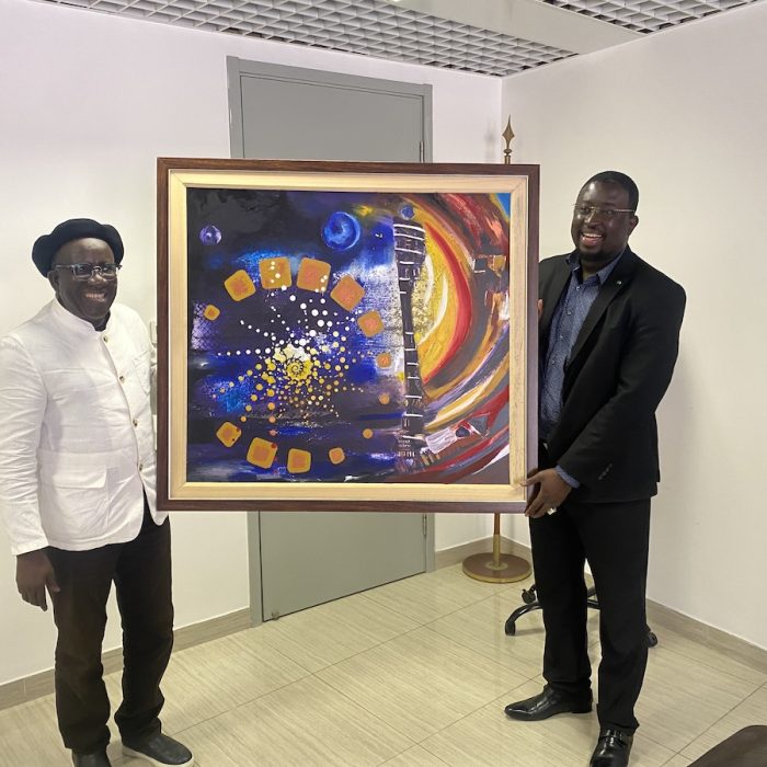 Kalidou Kassé handing over the artwork À la Rencontre de l’Astéroïde to Marame Kaïré, Director of the Senegalese Space Studies Agency.